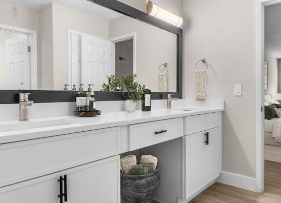 A bathroom with two sinks and a large mirror. at Riverchase Landing, Alabama