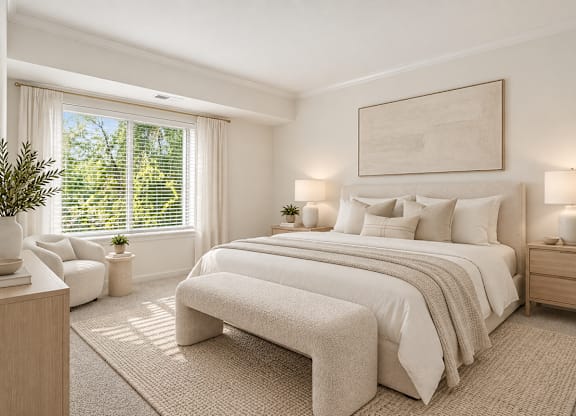 A bedroom with a large bed, a chair, and a potted plant.