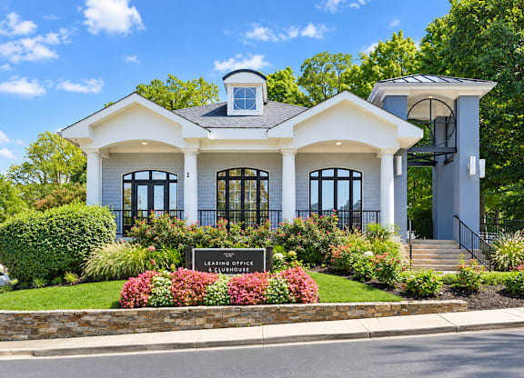 A white house with a sign that says "Leasing Office".