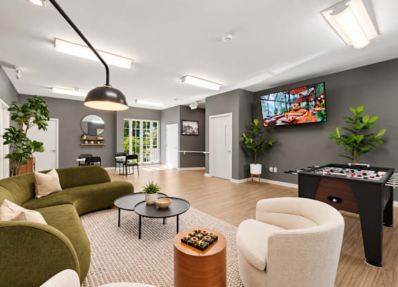 A living room with a green couch, a coffee table, and a television.