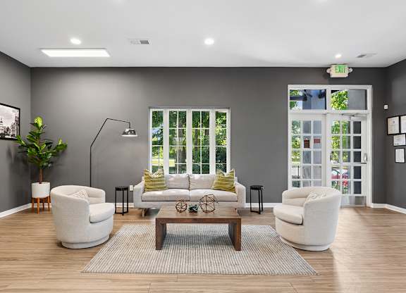 A living room with a grey wall and a large window.