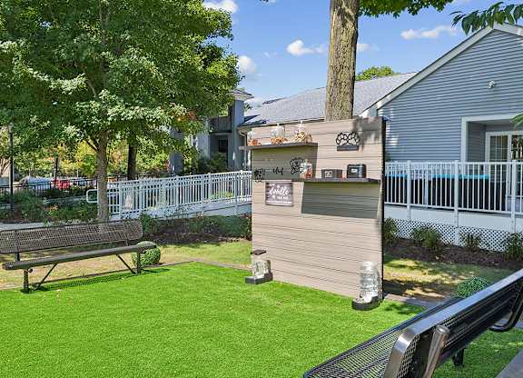 A park with a bench and a fence.