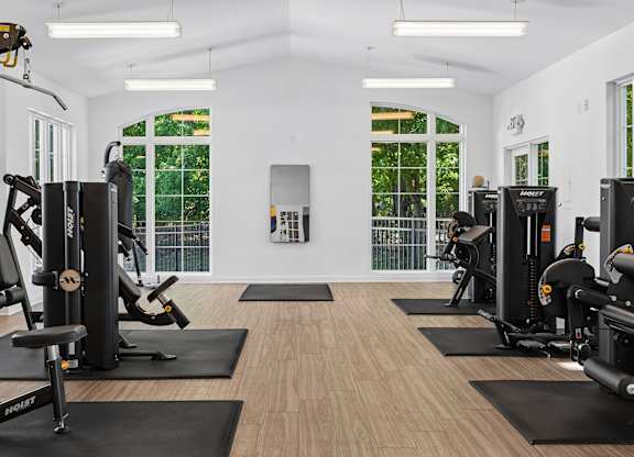 A gym with a variety of equipment including treadmills, weights, and exercise machines.