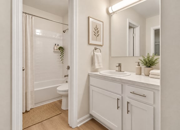 Bright bathroom with white vanity and tub shower combo at The Courts at Fair Oaks Apartments, Fairfax