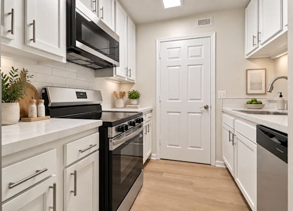 Galley kitchen with white cabinets and skylight at The Courts at Fair Oaks Apartments, Fairfax, VA