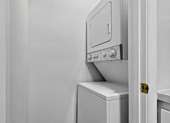 Stacked washer and dryer unit in laundry closet at The Courts at Fair Oaks Apartments, Fairfax, VA 22030