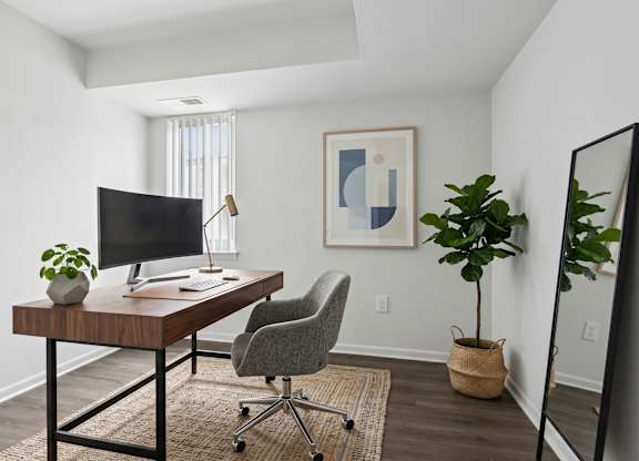 Modern workspace with curved monitor and desk lamp at The at Elmwood Terrace Apartments, Frederick, 21702
