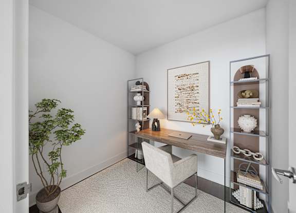A room with a desk, chair, and shelves with decorative items.