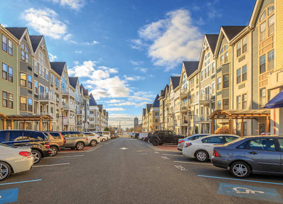 Street view with angle parked cars and townhomes at Pier Village Apartments, Long Branch
