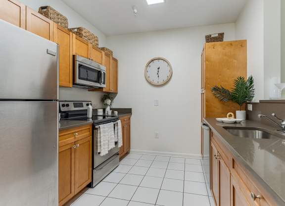 Galley kitchen with stainless appliances and wood cabinets at Pier Village Apartments, Long Branch, NJ 7740