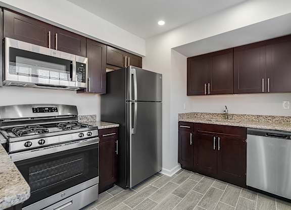 A kitchen with a stove, refrigerator, and cabinets. at Chatham Hill, New Jersey, 07928