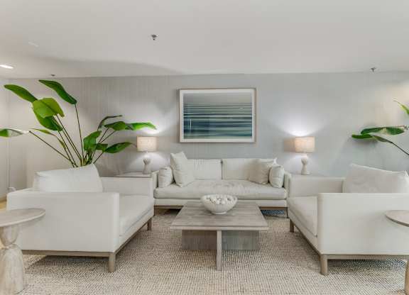 Elegant living room with white sofas and coastal artwork at Pier Village Apartments, Long Branch