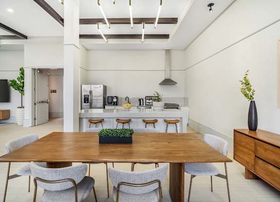 A dining room with a wooden table and chairs at The Addison, Baton Rouge