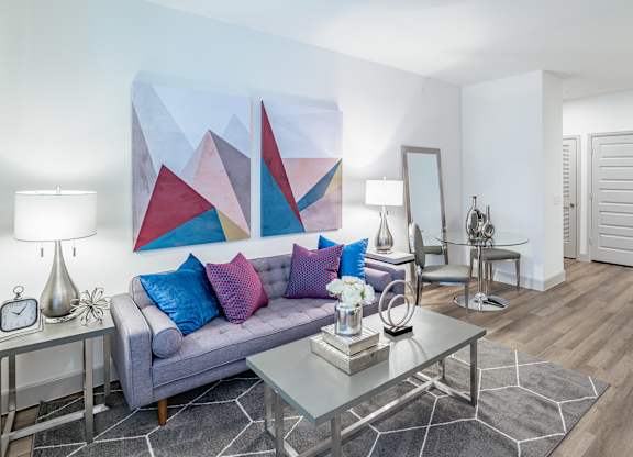 Grey sofa with blue pillows at Alys Crossing Apartments, TX, 77433