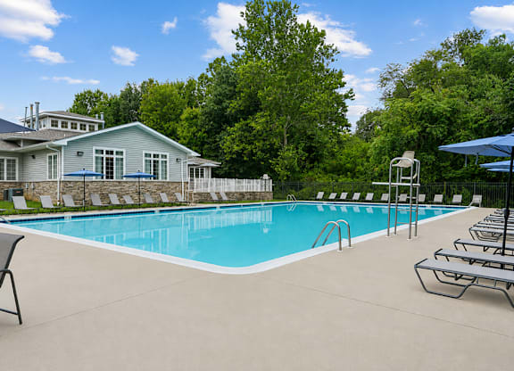 A pool with a house in the background.