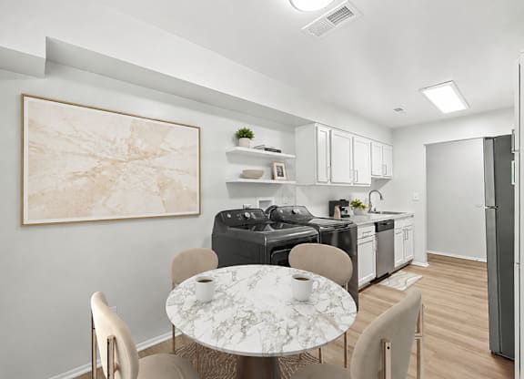 A modern kitchen with a marble table and chairs.