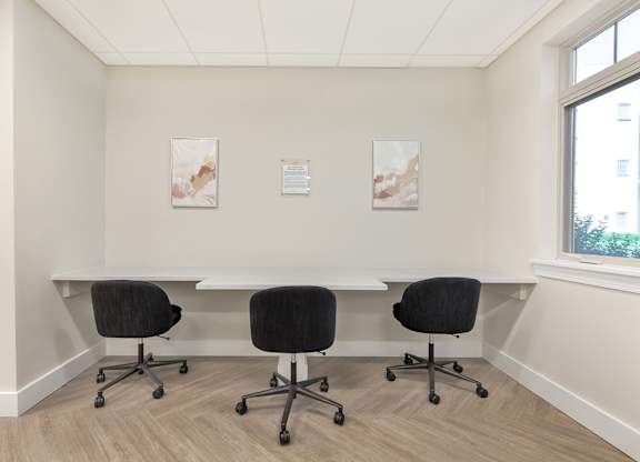 a conference room with a table and chairs and two paintings on the wall at Copper and Quarry Village, Maryland, 21209