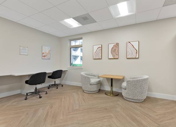 a waiting room with chairs and a table in front of a window at Copper and Quarry Village, Maryland, 21209