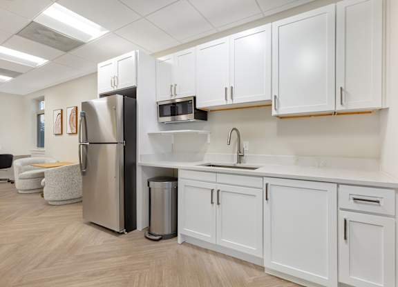 a kitchen with white cabinets and a stainless steel refrigerator at Copper and Quarry Village, Pikesville, MD, 21209
