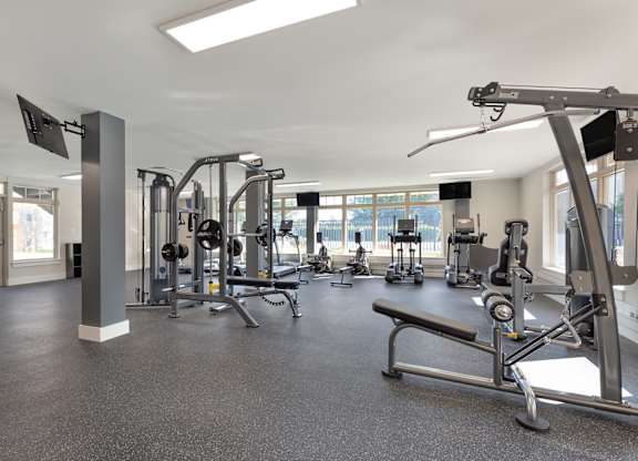 a gym with weights and other exercise equipment in a building with windows at Copper and Quarry Village, Pikesville