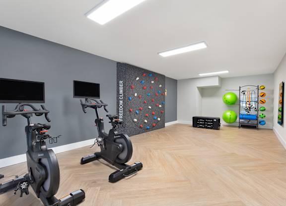 a gym with exercise machines and a rock climbing wall at Copper and Quarry Village, Maryland, 21209