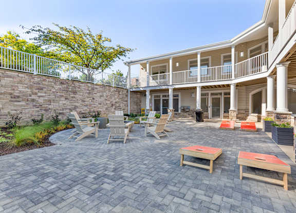 a patio with tables and chairs in front of a house at Copper and Quarry Village, Pikesville, MD