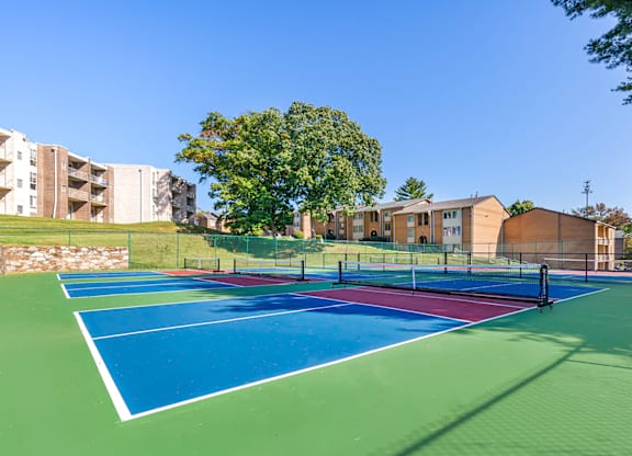 tennis courts with apartments in the background at Copper and Quarry Village, Pikesville