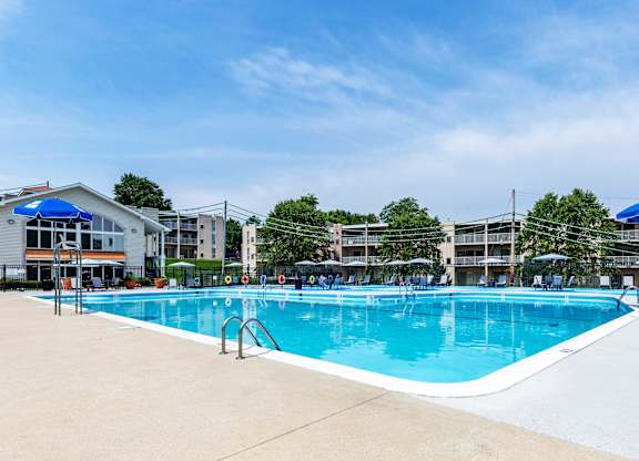 a swimming pool with umbrellas and buildings in the background at Copper and Quarry Village, Pikesville