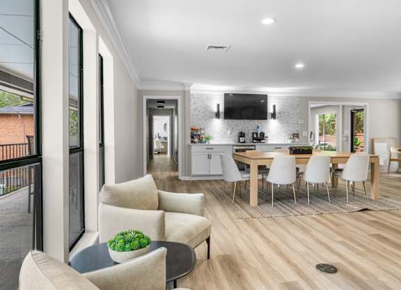 A modern living room with a dining area and kitchen in the background. at Riverchase Landing Apartments, Hoover