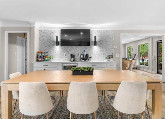 A modern kitchen with a wooden dining table and chairs. at Riverchase Landing Apartments, Hoover, Alabama