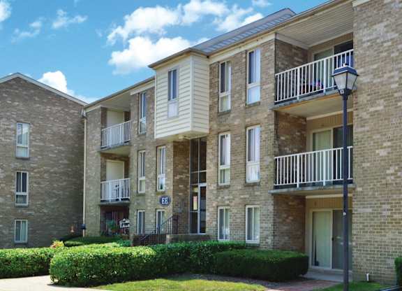 Multistory brick apartment complex with white balconies at The at Elmwood Terrace Apartments, Maryland