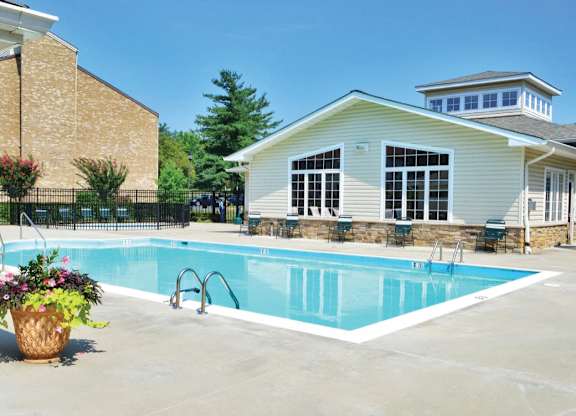 Swimming pool with clubhouse and sun loungers at The at Elmwood Terrace Apartments, Frederick, MD