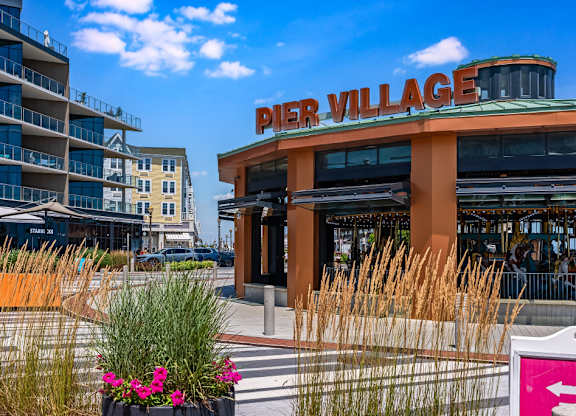 Property entrance sign with ornamental grasses at Pier Village Apartments, Long Branch, NJ
