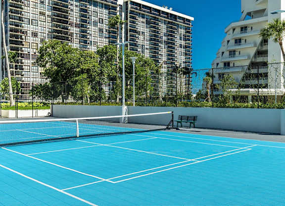 a blue tennis court in a city with tall buildings at The Hamilton, Miami, 33137