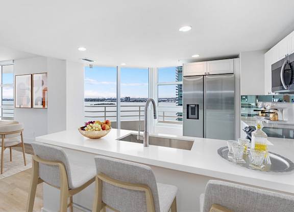 an open kitchen and dining area with a view of the ocean at The Hamilton, Miami