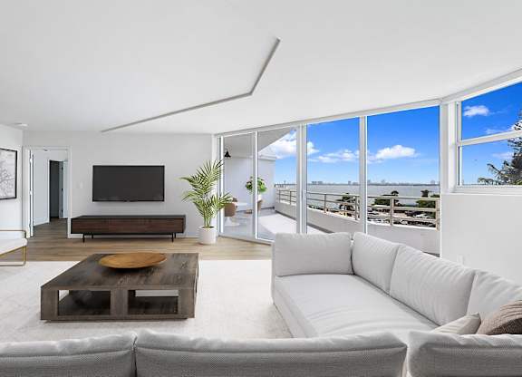 a living room with a white couch and a television at The Hamilton, Miami, FL