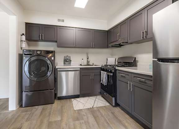 a kitchen with gray cabinets and stainless steel appliances at Copper and Quarry Village, Maryland, 21209