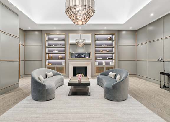 A modern living room with grey and gold accents.