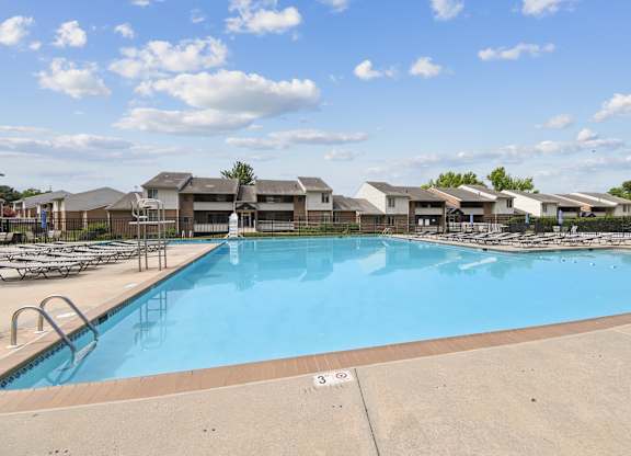 A large swimming pool with a blue tinted water and a white line on the ground.