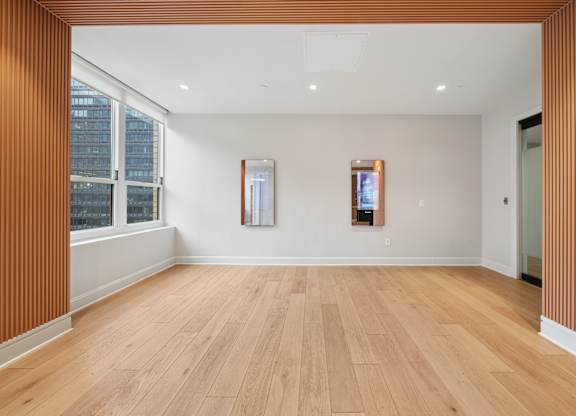 A room with wooden floors and two framed pictures on the wall.