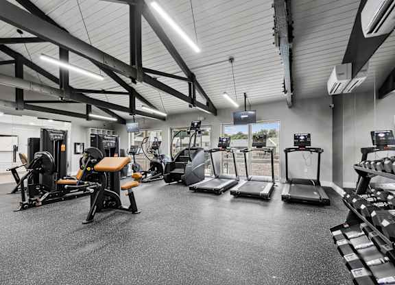 A gym with treadmills, weights, and exercise equipment.