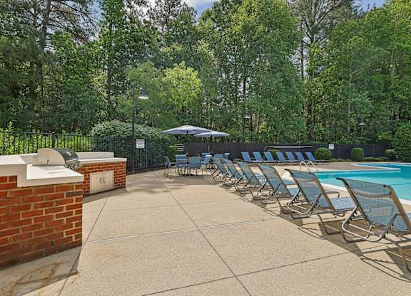 A poolside area with sun loungers and a brick wall.