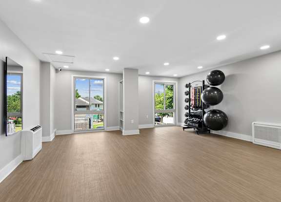 A spacious room with wooden flooring and a balloon exercise equipment set up.
