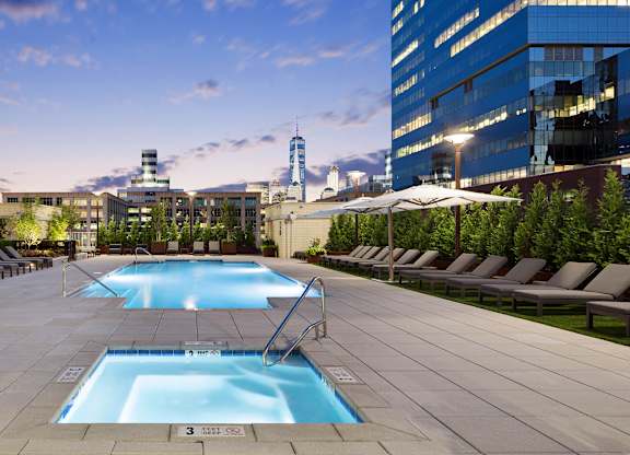 A large swimming pool surrounded by lounge chairs and umbrellas.