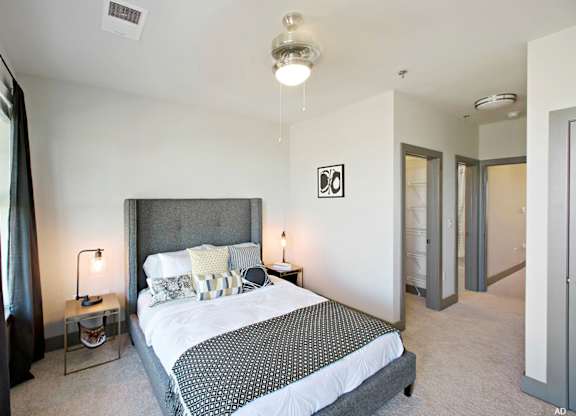 a bedroom with a bed and two nightstands at The Addison, Baton Rouge, Louisiana