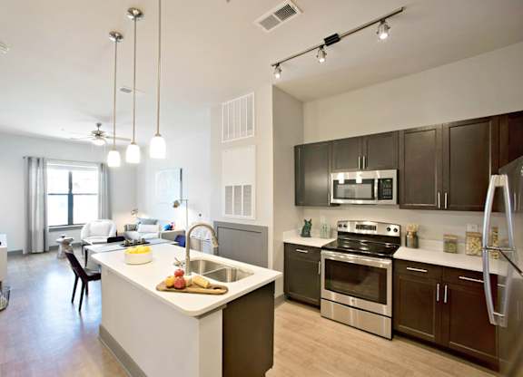 a kitchen with a large island and stainless steel appliances at The Addison, Baton Rouge, 70836