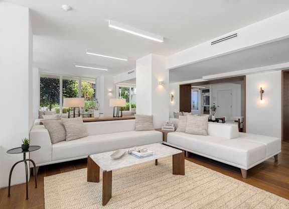 Bright living room with modern white sofas at The Hamilton Apartments, Miami, Florida