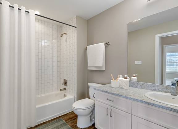 a bathroom with a shower and a toilet and a sink at Villaggio Apartments, Bossier City