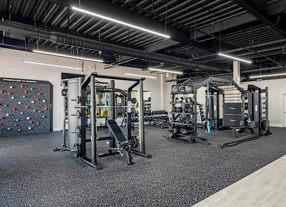a gym with weights machines and a rock wall at Villaggio Apartments, Bossier City, LA