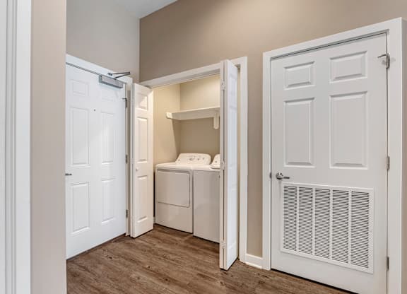 a laundry room with a washer and dryer and a closet with a door at Villaggio Apartments, Louisiana